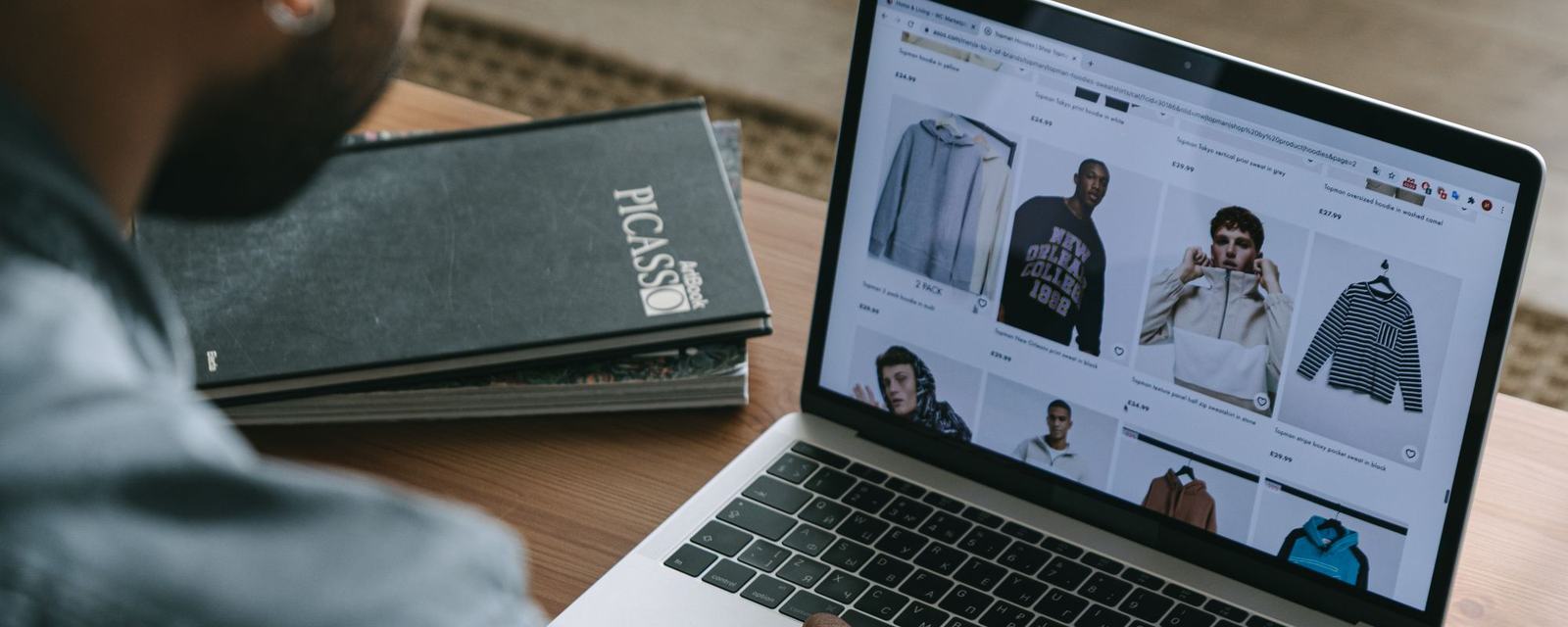 Bilgisayarda online mağazanın ürün sayfasını inceleyen kişi